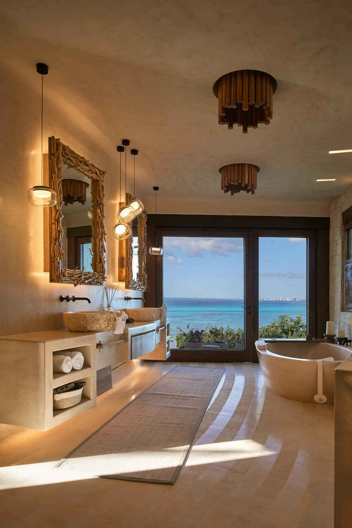 Baño con doble lavabo y tina exenta frente al mar en Villa Wayak