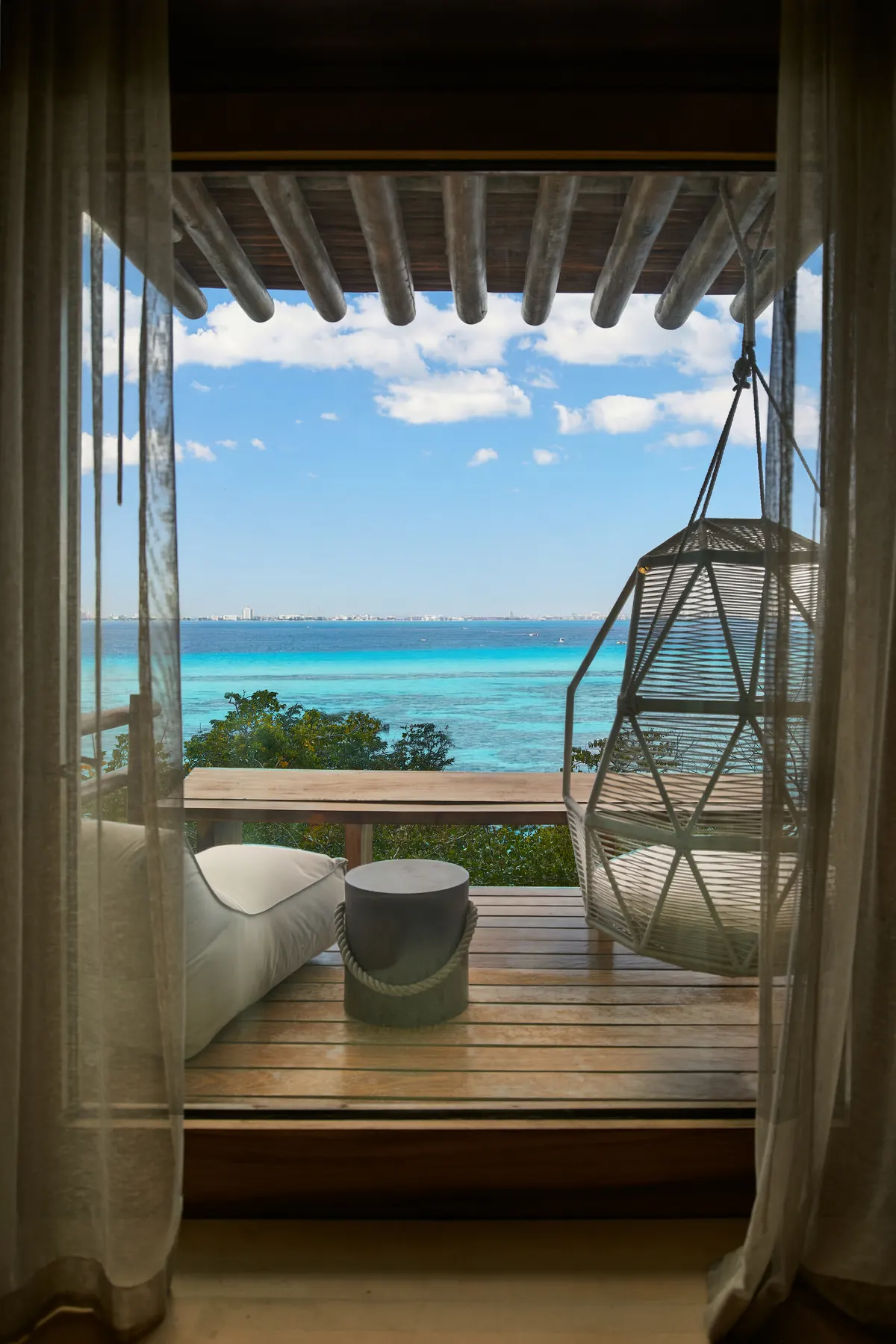 Terraza con silla colgante y vista al mar en Villa Wayak