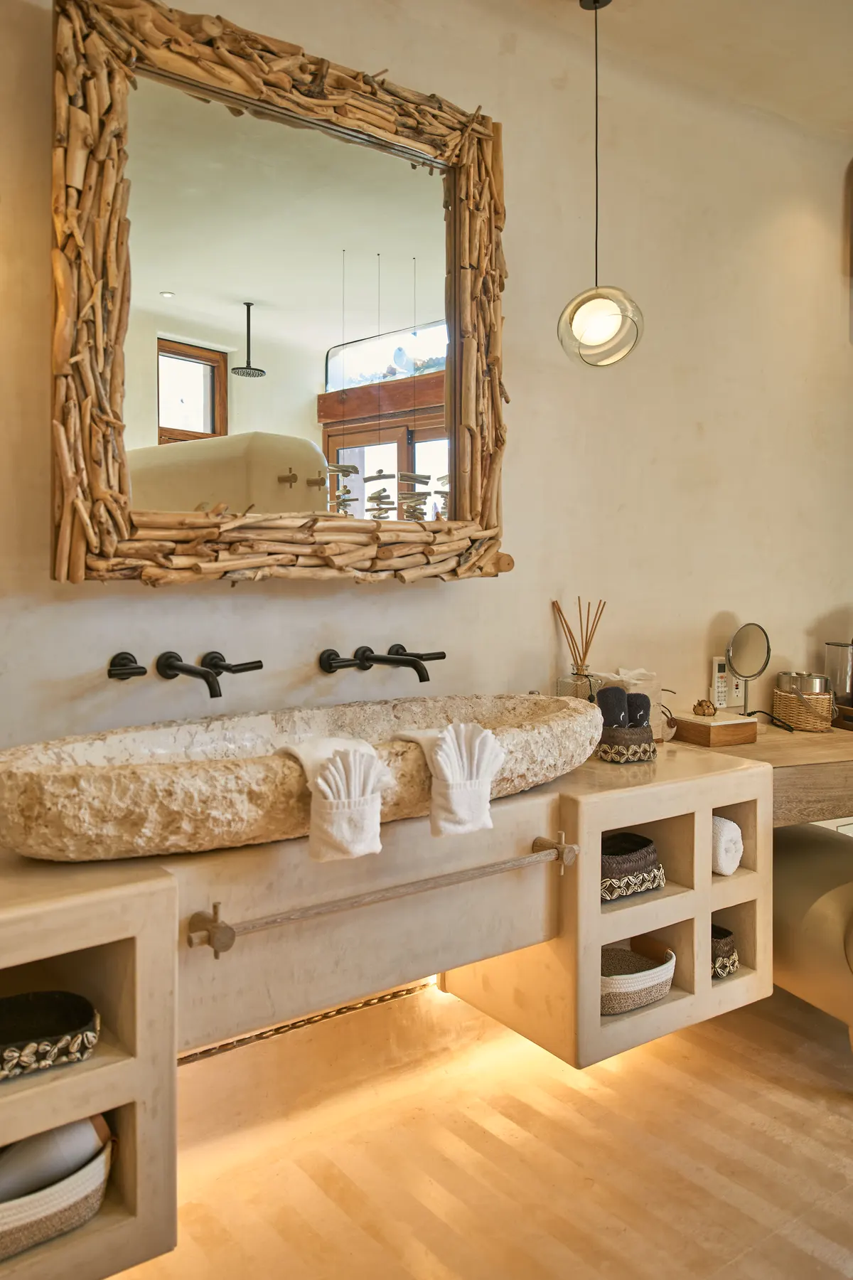 Lavabo de piedra tallada con espejo de madera en Villa Wayak