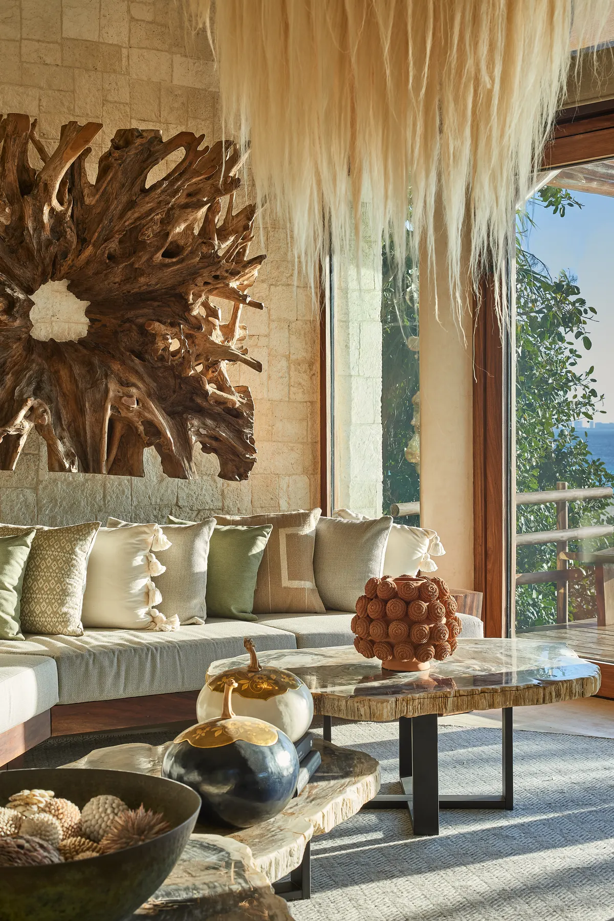 Sala con arte de raíz de madera y vista al jardín en Villa Wayak