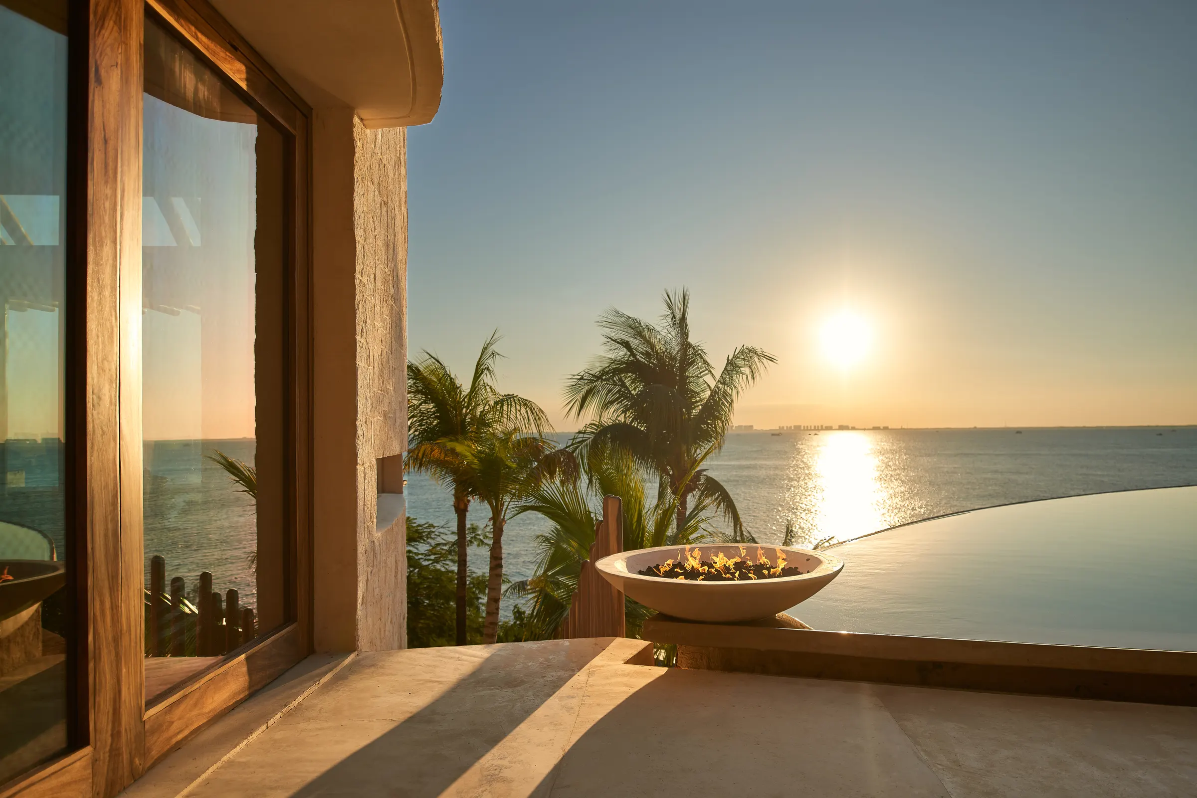 Terraza con fogata encendida al atardecer en Villa Wayak
