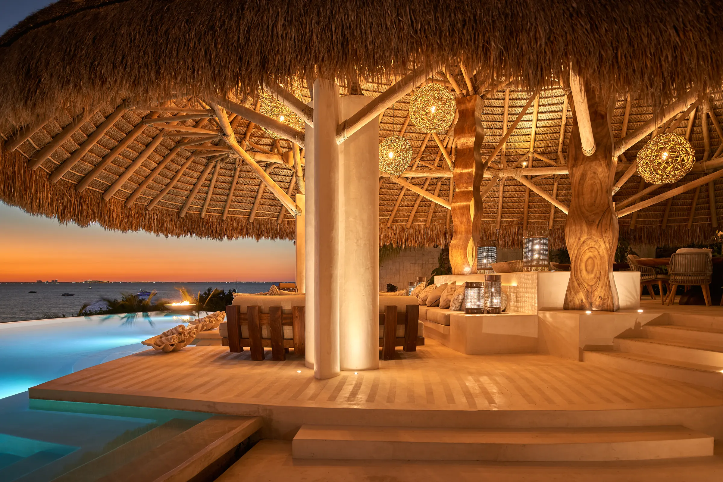 Palapa lounge con columnas de madera y vista a la alberca en Villa Wayak