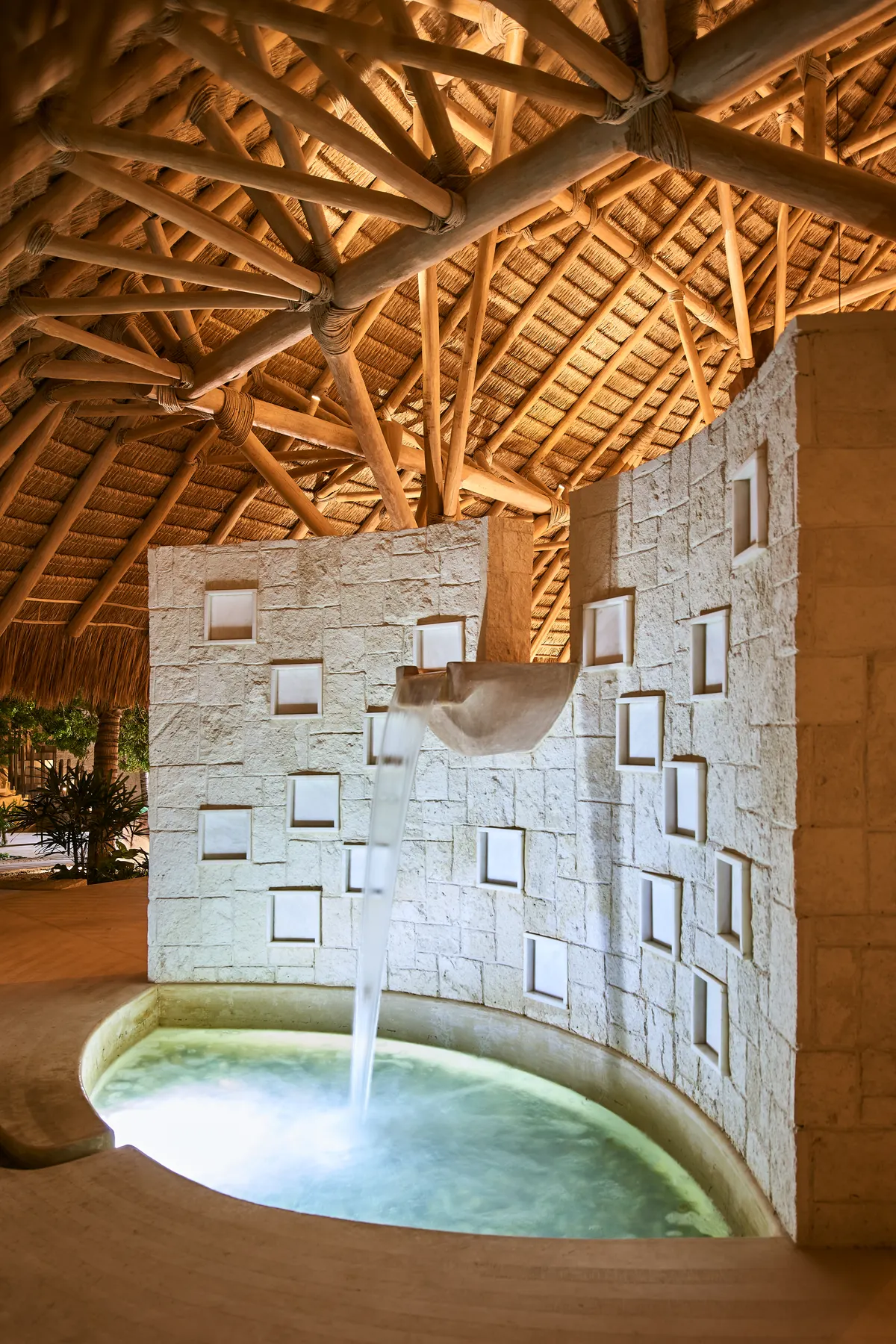 Fuente de agua y alberca de piedra en el spa de Villa Wayak