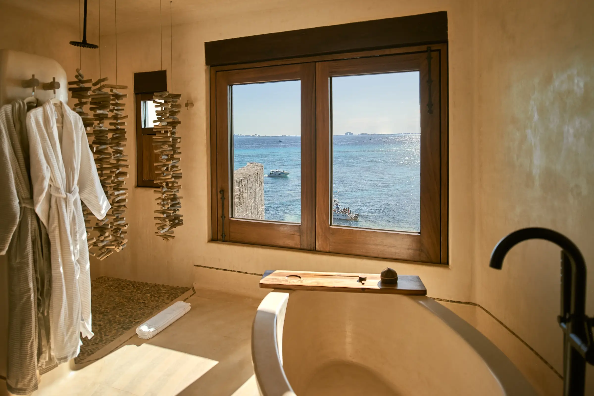 Habitación de baño con ventana al mar en Villa Wayak